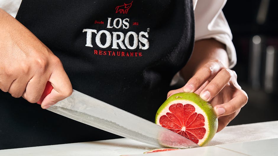 Close-up of chef slicing grapefruit wearing Los Toros Restaurant apron