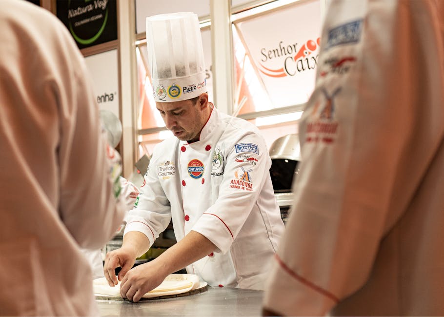 A chef in uniform preparing dough in a professional kitchen setting