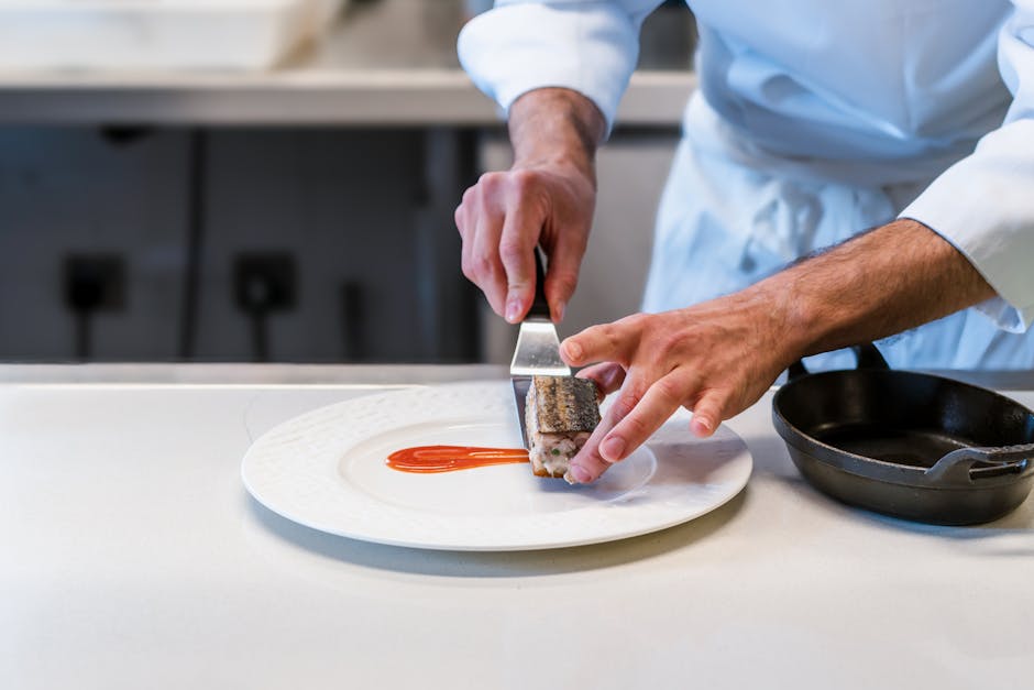 Close-up of a chef plating a gourmet meal, showcasing culinary precision and artistry